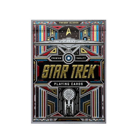 Star Trek žaidimo kortos dėžutė, juoda su auksiniu reljefiniu logotipu ir spalvotais futuristiniais ornamentais, priekinė pusė koncentrine erdvėlaivio grafika
