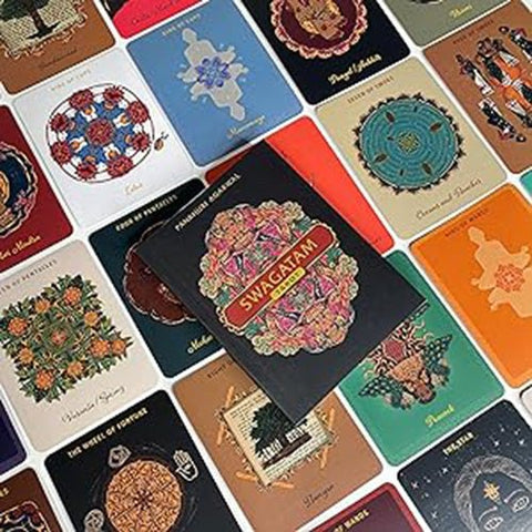 Tarot kortos Swagatam juodu viršeliu centre, dėžutė atidengiama ant įvairių spalvotų kortų nugarėlių, pabrėžiant variantų dizainus