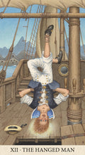 tarot korta Pakabintas žmogus — laive pakabintas aukštyn kojomis jūreivis mėlyno‑baltu kostiumu, detali iliustracija