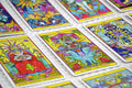 Tarot kortos ryškus psichodelinis komplektas išdėstytas plokščiai, artimas kampinis kadras akcentuoja kortų detales ir simboliką