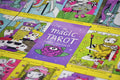 Tarot kortos The Magic Tarot su violetine dėkle ir ryškiomis, geltonu rėmeliu apvestomis didžiųjų arkanų kortelėmis, plokščiai išdėstytos