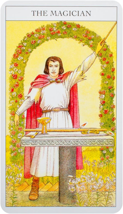 tarot korta Magas (Rider–Waite), priekinė kortelės pusė: baltas kostiumas, raudonas apsiaustas, pakelta lazda ir ant stalo esančios simbolinės taurė ir kardas