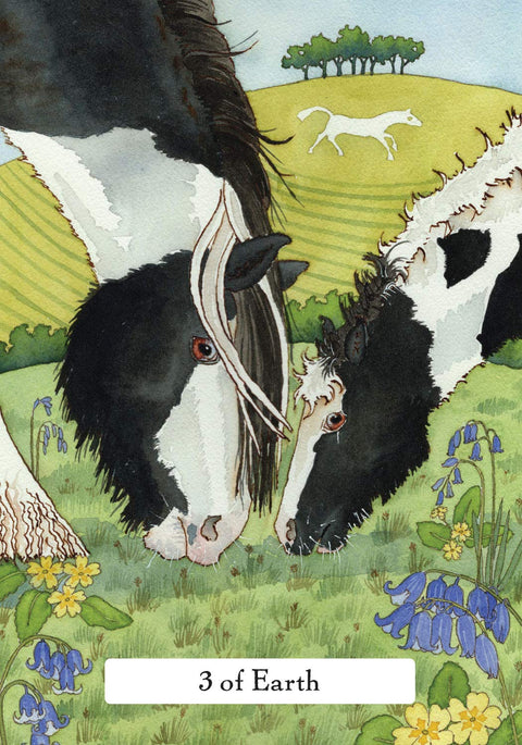 tarot korta 3 of Earth: dvi juodai baltos karvės ganosi žaliame lauke su mėlynomis žibuoklėmis ir balta arklio figūra kalvoje