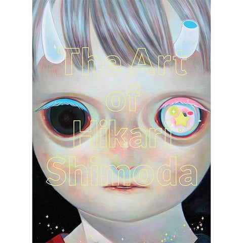 knyga The Art of Hikari Shimoda — priekio viršelis su pastelinio stiliaus vaikų veidu, viena akis juoda, kita spalvota ir tekstu ant viršelio