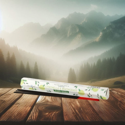 Smilkalai Citronella & Lemongrass, baltame dėkle su juodais ir raudonais koteliais, priekinis kampas ant medinio stalo kalnų fone