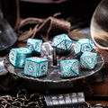 RPG kauliukų rinkinys turkio spalvos metaliniai (7 v.), su įmantriais keltų raižiniais, iš viršaus ant metalinio padėklo