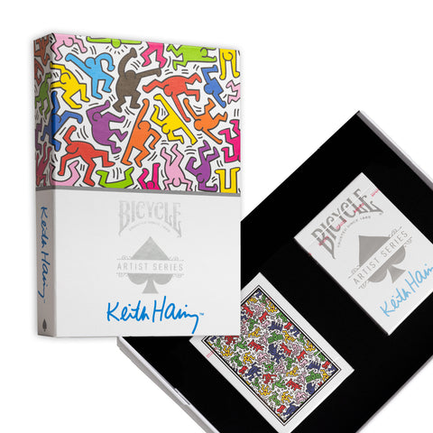 Bicycle kortos Keith Haring dovanų dėžutėje — atidaryta juoda dėžutė su dviem kaladėmis ir margu Keith Haring nugarėlės raštu