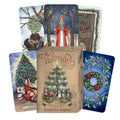 Tarot kortos Yuletide – kieta dėžutė su šventine eglute ir kelios iliustruotos kortos, parodytos fanuotai, komplektas